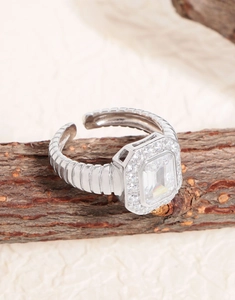 Macro shot of silver twisted band ring with emerald cut cubic zirconia on wood
