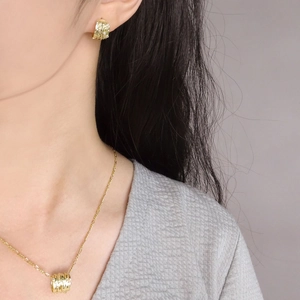 Set di collana e orecchini in oro testurizzato con linee irregolari dal look moderno