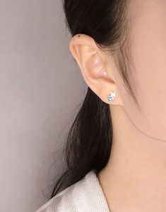 Détail de la boucle d'oreille étoile en argent S925 avec zircon bleu sur l'oreille