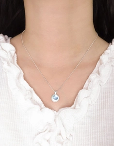 Detail of natural aquamarine pendant necklace on model with brushed silver finish