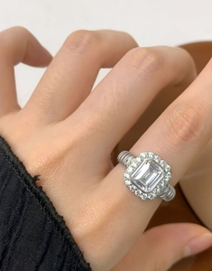 Macro detail of emerald cut zircon ring with twisted silver band on a hand