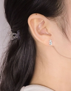 Gros plan d'un clou d'oreille étoile en argent sterling S925 porté par un mannequin