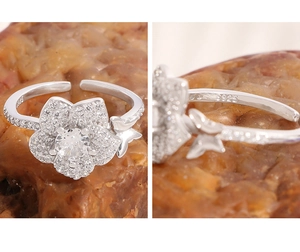 Dettaglio di un anello in argento S925 con fiori in zircone e una piccola farfalla