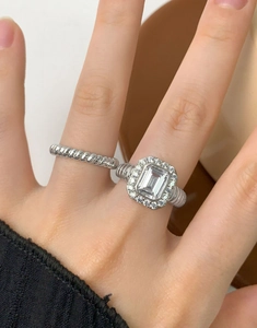 Detailed view of S925 silver twist ring and emerald-cut zircon ring set on hand