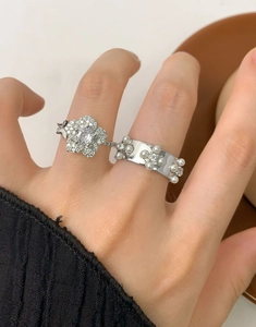 Dettaglio di anelli in argento S925 con fiore di cristallo e perle in stile aperto