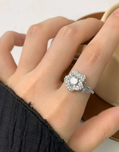 Dettaglio dell'anello a fiore in argento S925 con zircone tondo e petali micro-pavé