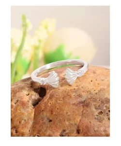 Macro shot of S925 sterling silver shell ring with intricate engraving on a textured rock