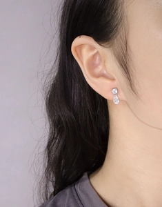 Close-up of elegant S925 silver pear-shaped zircon drop earrings on a model ear