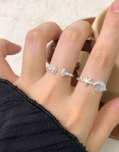 Detail of silver starfish and seashell open rings with sparkling stone accents