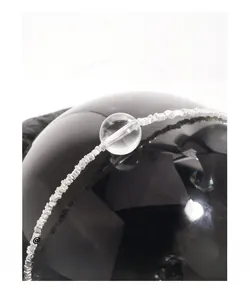 Vue macro du bracelet perlé en argent sterling S925 avec un pendentif sphère en cristal