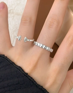 Macro shot of silver shell open ring and textured band with zircon stones for women