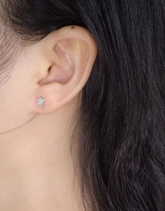 Close-up of minimalist S925 sterling silver mushroom stud earring with zircon on ear