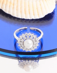 Macro shot of S925 sterling silver ring with natural pearl and zircon sun flower detail