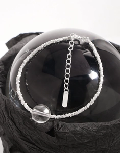 Détail macro du bracelet en argent S925 avec cristal transparent sur socle noir