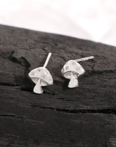 Macro shot of S925 sterling silver mushroom stud earring with zircon on black wood