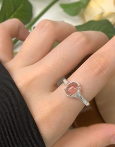 Macro shot of oval strawberry quartz stone in four-prong S925 silver ring setting