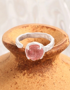 Detail of S925 silver ring with hammered texture and round strawberry quartz stone