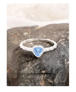 Close-up of S925 sterling silver stamp and blue heart zircon on wavy ring band
