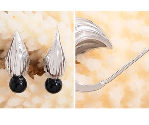 Macro detail of S925 sterling silver shell earrings with black onyx bead and purity stamp