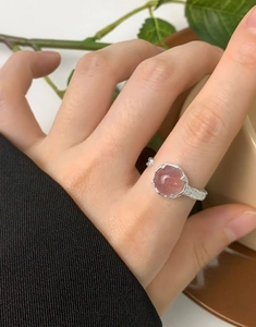 Close-up of S925 sterling silver ring with natural strawberry crystal on a hand