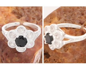 Macro detail of S925 sterling silver stamp and zircon flower setting on open ring