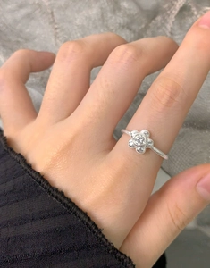 Close-up of S925 sterling silver flower ring with zircon stone on finger