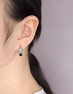 Close-up of S925 sterling silver waterdrop earrings with black onyx pendant on model