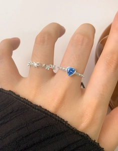 Close-up of S925 silver ring featuring blue heart-shaped gemstone and bow design