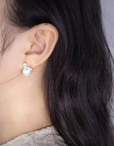 Detail eines eleganten S925 Silberohrrings mit weißer Perle und Zirkonia-Stein
