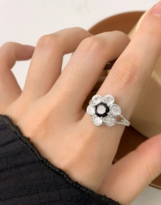 Macro shot of S925 silver flower ring with black zircon center and clear petals