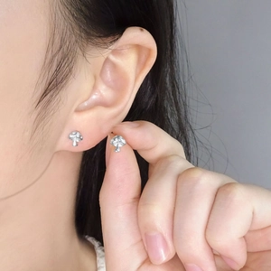 S925 sterling silver mushroom stud earrings with cubic zirconia, held for size comparison
