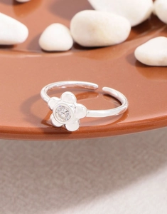 Macro shot of silver S925 flower ring with zircon stone on decorative stones