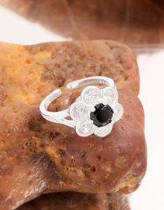 Macro shot of S925 sterling silver flower ring with black gemstone and zircon petals