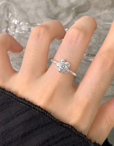 Close-up of S925 sterling silver flower ring with zircon stones worn on finger