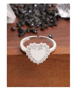 Vue macro d'une bague cœur en argent S925 avec pavé de zircons sur bois sombre
