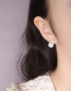 Eleganz eines S925 Silberperlenohrrings mit Zirkonia-Inlay am Ohr einer Frau