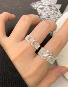 Macro di anelli in argento con motivo a nido d'ape e a cuore indossati sulle dita