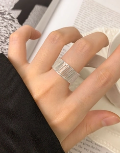 Dettaglio ravvicinato dell'anello a maglia a nido d'ape traforata in argento