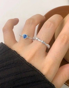 Close-up of S925 silver ring set with blue heart-shaped stone and multi-heart band