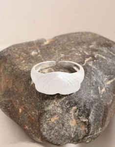 Dettaglio dell'anello a cuore in argento S925 spazzolato opaco su base di pietra scura