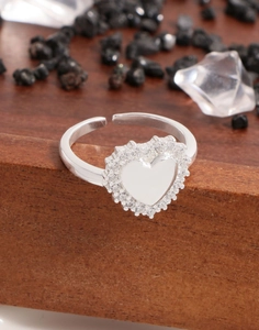 Vue macro d'une bague coeur en argent S925 sertie de zircons sur fond de bois