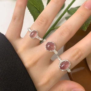 Three textured S925 sterling silver rings with pink strawberry quartz on a model's hand