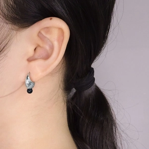 S925 sterling silver shell earrings with black onyx bead shown on a model profile
