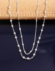 Dettaglio di una collana a due strati in argento con perle stile minimalista