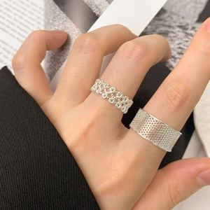 Set di anelli in argento S925 con motivi a nido d'ape e maglie sulla mano della modella