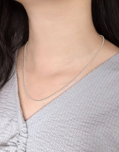 Dettaglio di una collana a catena con sfere in argento sterling S925 su una modella