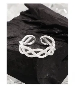 Macro detail of S925 sterling silver multi-line woven knot ring on black stone base