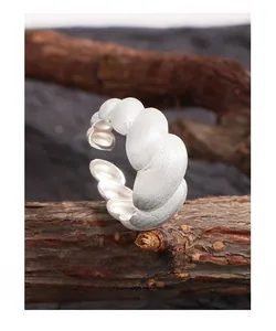 Detailed close-up of matte S925 sterling silver croissant ring on a wood branch