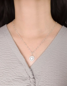 Dettaglio della collana con pendente a cuore d'argento indossata con catena a sfere