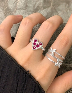Close-up of S925 sterling silver rings with heart red zircon and floral wrap design